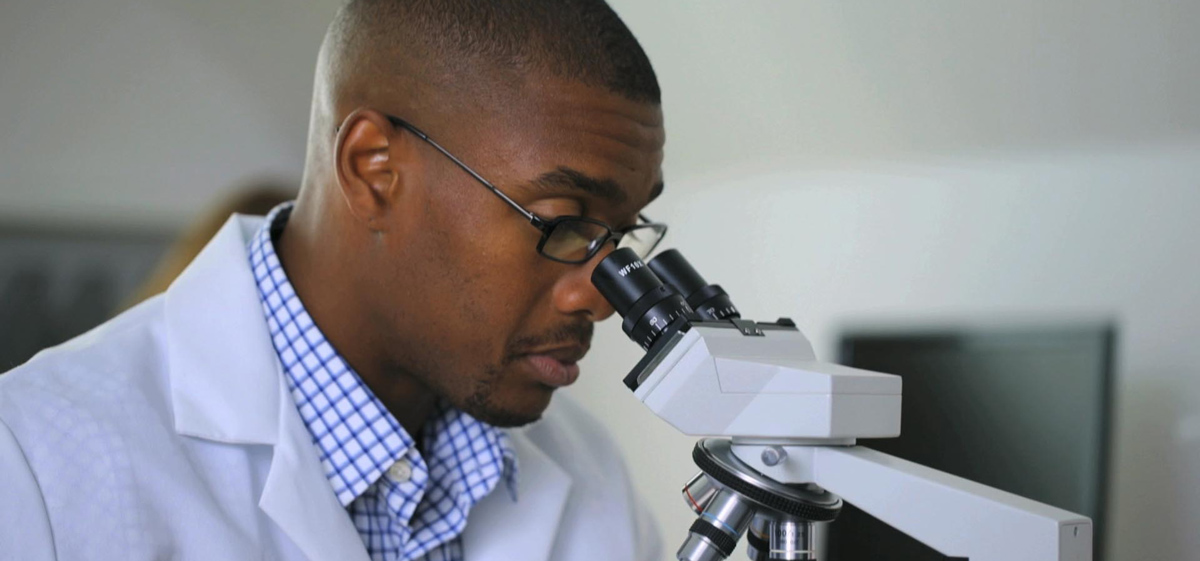 a man looks into a microscope